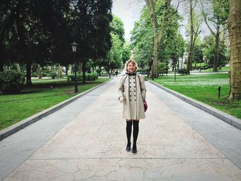 Full length portrait of young woman walking in park