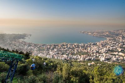 High angle view of town by sea against sky