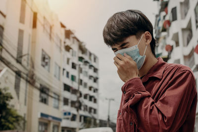 Portrait of young man drinking outdoors