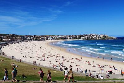 High angle view of people enjoying at beach against blue sky