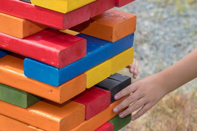 Cropped image of girl playing with colorful wooden blocks at playground