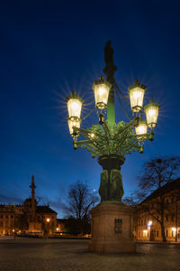 Low angle view of illuminated street light against blue sky