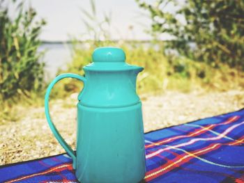 Close-up of tea cup on table in field