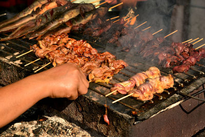 Cropped image of person preparing food on barbecue grill