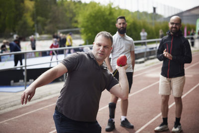 Men participating in sports competition on athletics track