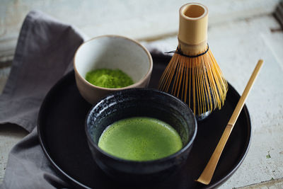 High angle view of cup of matcha tea on table