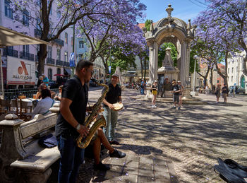 People on street against buildings in city