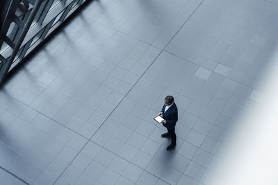 High angle view of man walking on tiled floor