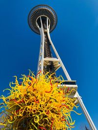 Low angle view of ferris wheel against clear blue sky