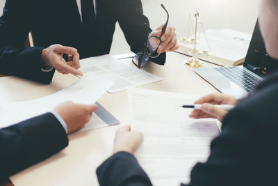 Close-up of colleague working at desk in office