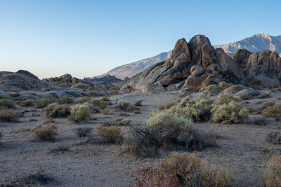 Scenic view of arid desert rock formations in landscape against clear sky