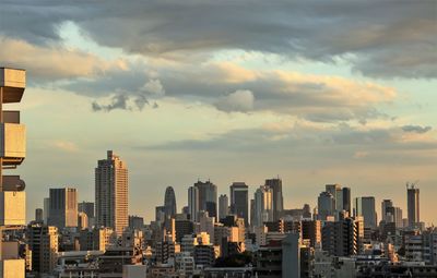 View of cityscape against cloudy sky