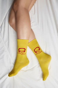 Midsection of woman relaxing on bed