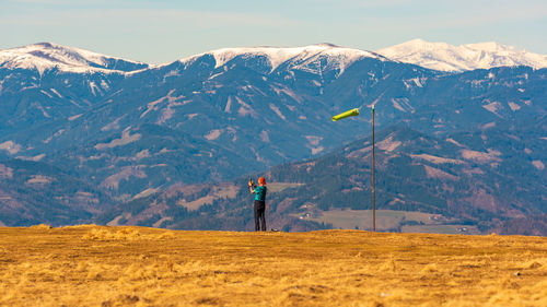 Full length of man standing on snowcapped mountain