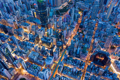 High angle view of illuminated street amidst buildings in city at night