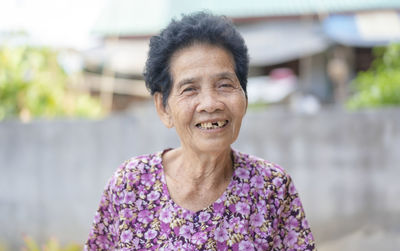 Old asian woman face with wrinkles elderly senior. smiling happiness with a few broken teeth 
