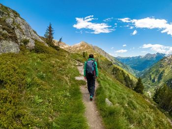 Woman hiking on footpath in the austrian alps near gastein, salzburg, austria