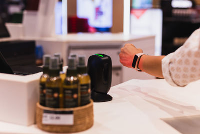 Customer making wireless payment using smartwatch at shopping store