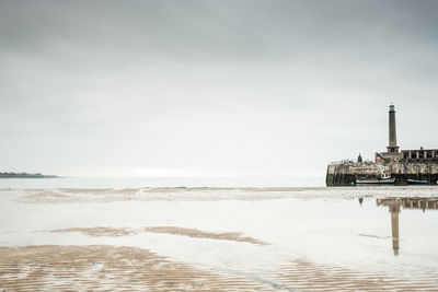 Scenic view of sea by building against sky