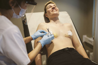 Patient after top surgery having bandages changed