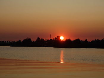 Scenic view of lake against romantic sky at sunset