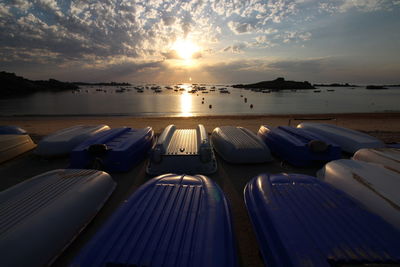 Boats at beach against sky during sunset