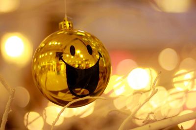 Close-up of golden bauble and christmas lights