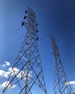 Electricity pylons standing against sky