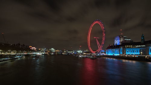 Illuminated ferris wheel in city at night - london eye