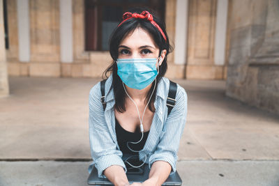 Portrait of young woman sitting on street