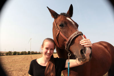 Portrait of woman with horse against sky