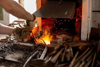 The blacksmith in production process of metal products, handmade in the forge. craftsman heats metal