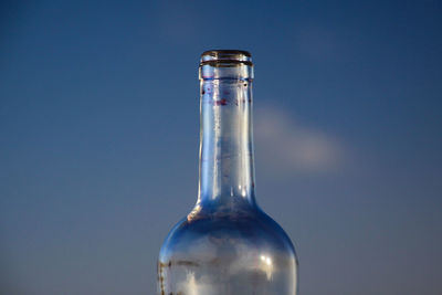 Close-up of glass bottle against blue background