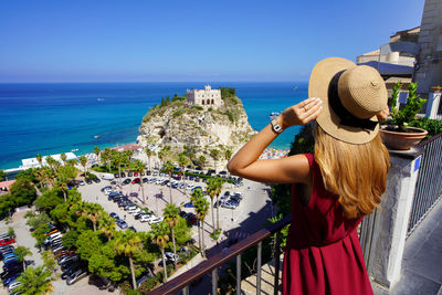 Girl enjoying view of tropea village on coast of the gods, calabria. summer vacation in italy.