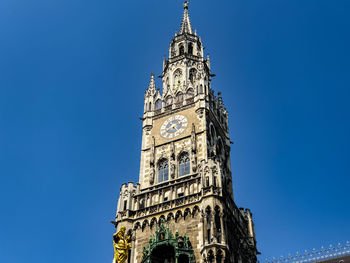 Low angle view of clock tower against blue sky