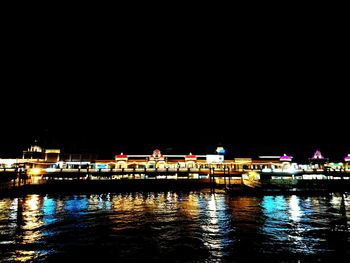Reflection of illuminated built structure against sky at night