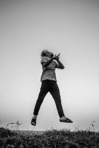 Woman standing on field against clear sky