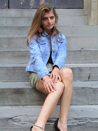 Portrait of a young woman sitting on staircase