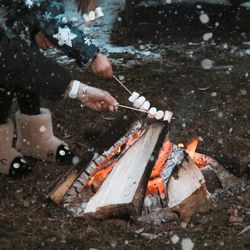 High angle view of man preparing fire on wood