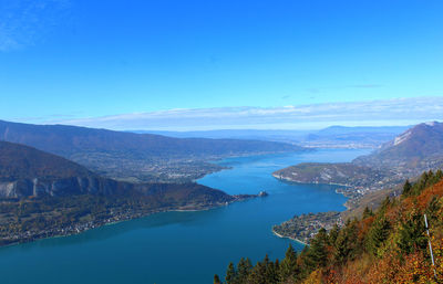 Scenic view of lake and mountains against blue sky