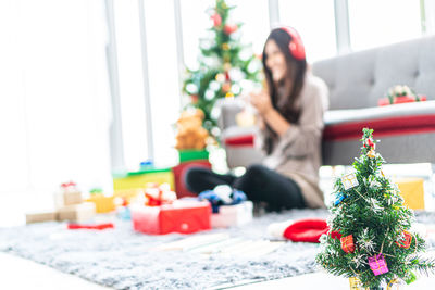 Woman sitting on christmas tree at home
