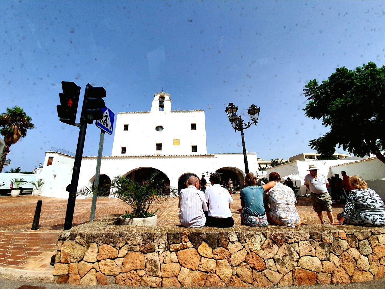 GROUP OF PEOPLE SITTING OUTSIDE BUILDING