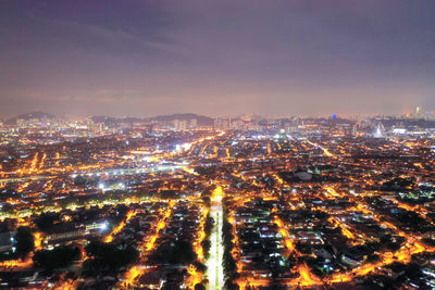 High angle view of illuminated cityscape against sky at night