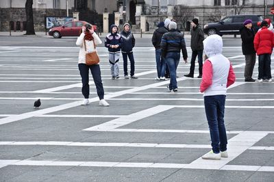 Rear view of people walking on city street