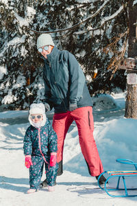 Mother and daughter on snow covered mountain