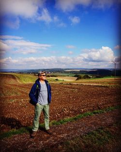 Full length of man standing on field against sky