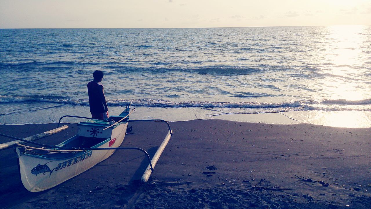 water, sea, horizon over water, lifestyles, beach, leisure activity, shore, men, tranquility, nautical vessel, full length, nature, tranquil scene, boat, scenics, vacations, beauty in nature, sky