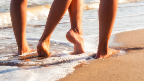 Low section of woman standing on beach