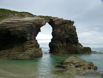 Rock formation on sea against sky