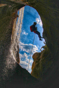 Reflection of man on rope against sky